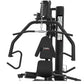 Black multi-station home gym with padded seat, chest press arms, lat pulldown attachment, and leg press platform on white bac