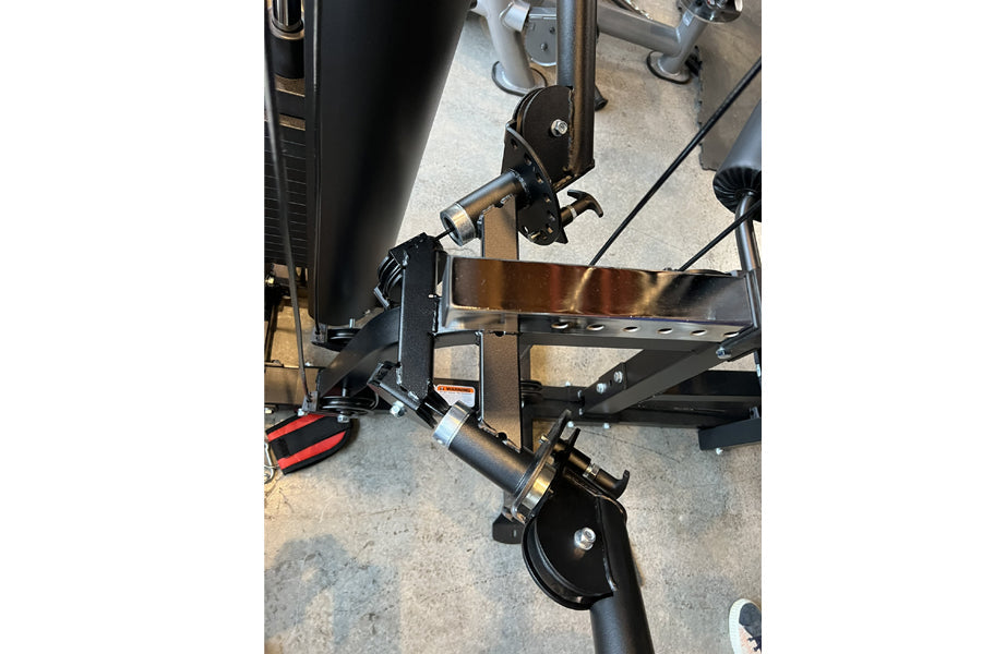 Warrior HG900 home gym leg press attachment with black metal frame, brown seat, and red pedal on concrete floor