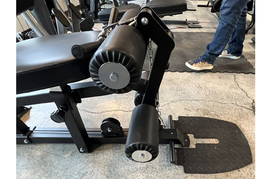 Warrior HG900 home gym leg press attachment with black metal frame, dual cylindrical footplates, and gray seat, displayed in 
