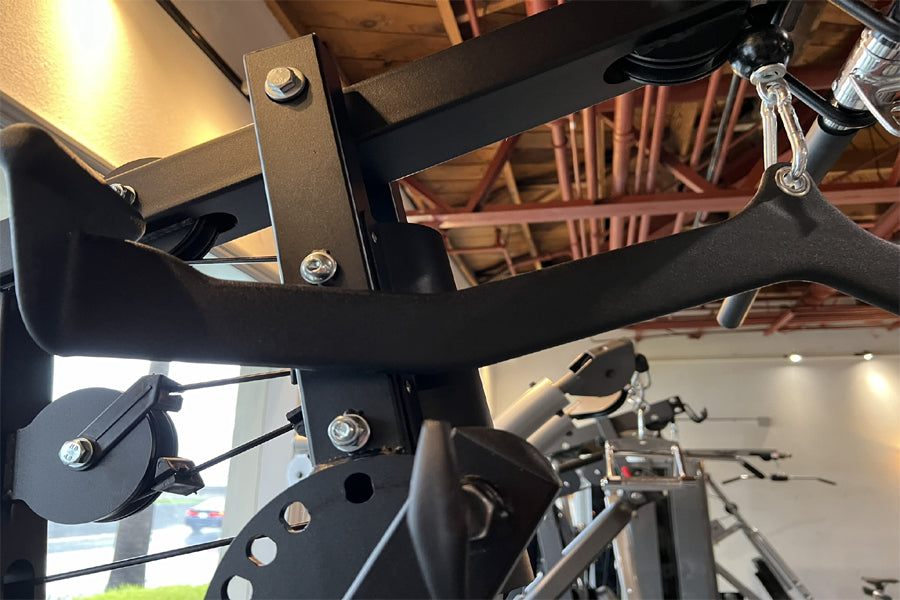 Warrior HG900 home gym with black frame and metal components, showing leg press attachment and weight plate holder in indoor 