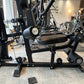 Black home gym equipment with leg press attachment and adjustable weight stack in gym facility setting
