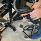 Person demonstrating leg press attachment on black Warrior HG900 home gym with foot pedal and straps