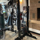 Black and silver cable machine with lat pulldown and low-row attachments in gym setting