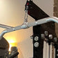 Warrior Lat Pulldown Low-Row Home Gym System with gray handles and black frame against brick wall