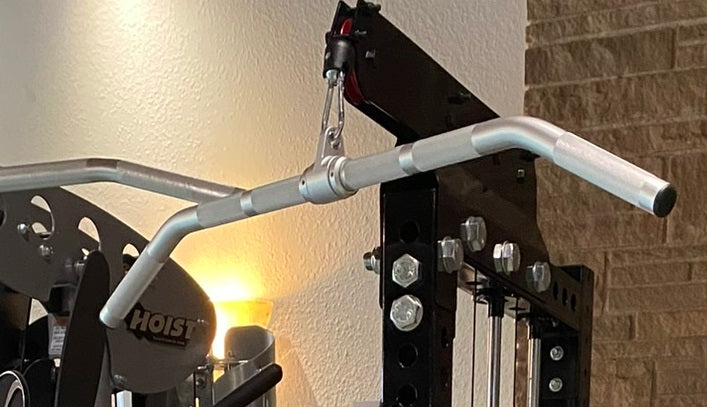 Warrior Lat Pulldown Low-Row Home Gym System with gray handles and black frame against brick wall