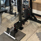 Black steel lat pulldown and low-row home gym system with weight stack and adjustable pulleys on garage floor