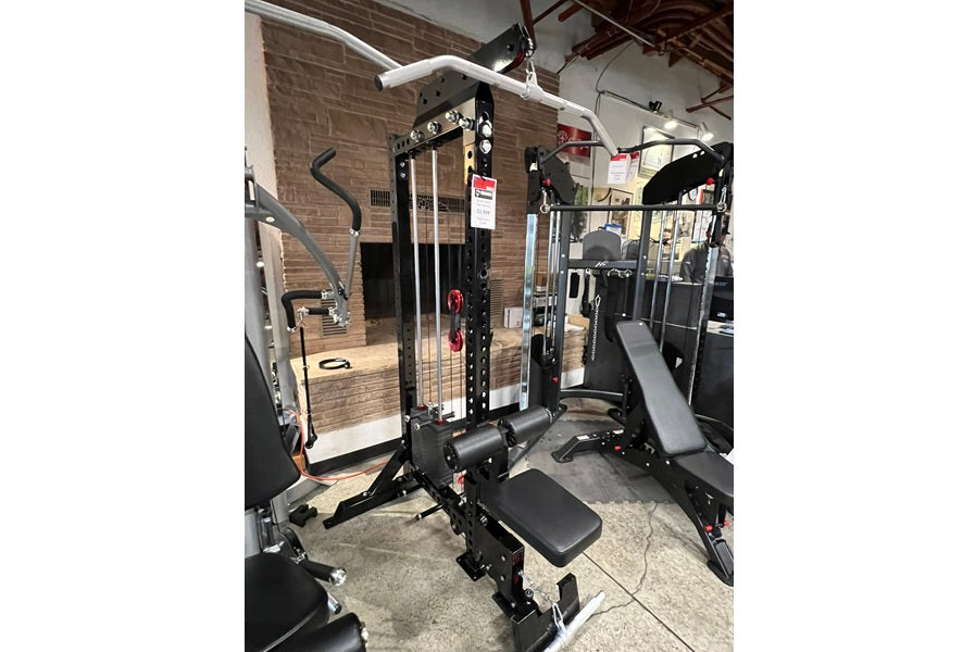 Black and white Warrior Lat Pulldown Low-Row home gym system with weight stack and adjustment pins in commercial gym setting