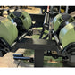 Pair of sage green adjustable dumbbells with black accents and handles on black dumbbell stand in gym setting