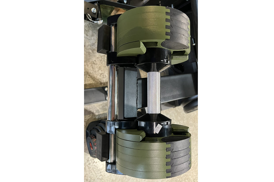 Warrior Newbells 50lb adjustable dumbbells in tactical green and black with metal weight plates, vertical storage configurati