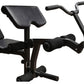 Black multi-function weight bench with padded seat and backrest, leg extension attachment, and curved handlebar, on white bac