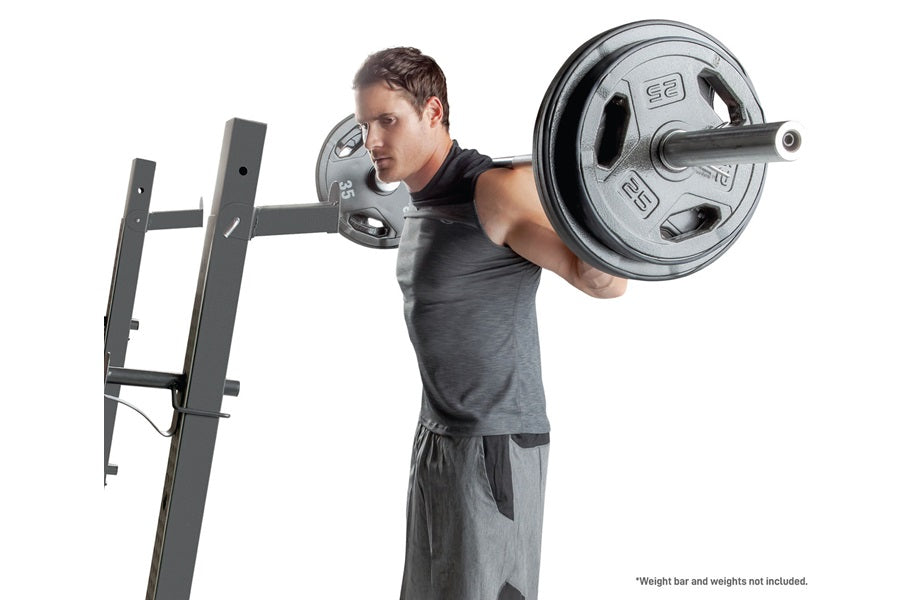 Man in black tank top performing shoulder press on black steel Olympic weight bench with loaded barbell bar on white backgrou