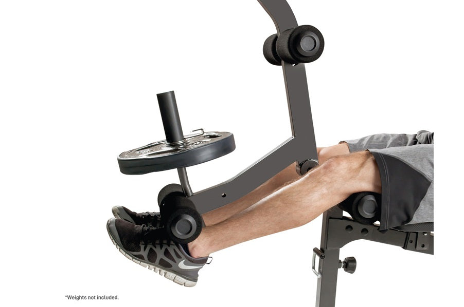Dark gray Olympic weight bench with leg extension attachment, shown with male model demonstrating leg press position on white