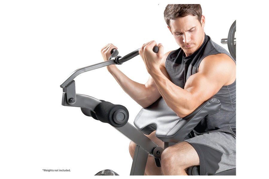 Man seated on gray and black multi-function weight bench with adjustable barbell attachment, demonstrating exercise position 