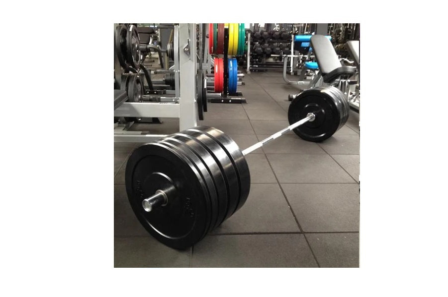 Warrior Premium Bumper Plates with black rubber and metal rings on white barbell in gym setting