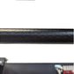Black textured steel power rack tube with diamond plate pattern detail, close-up view
