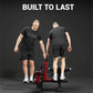 Two men wearing black t-shirts and shorts demonstrate the Warrior Signature Commercial Plate-Loaded Leg Extension/Prone Leg C