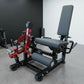 Red and black commercial leg extension and prone leg curl machine with padded seat, adjustable backrest, and weight plate peg