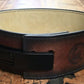 Brown leather weightlifting belt with black buckle and cream suede lining, flat lay on wooden surface