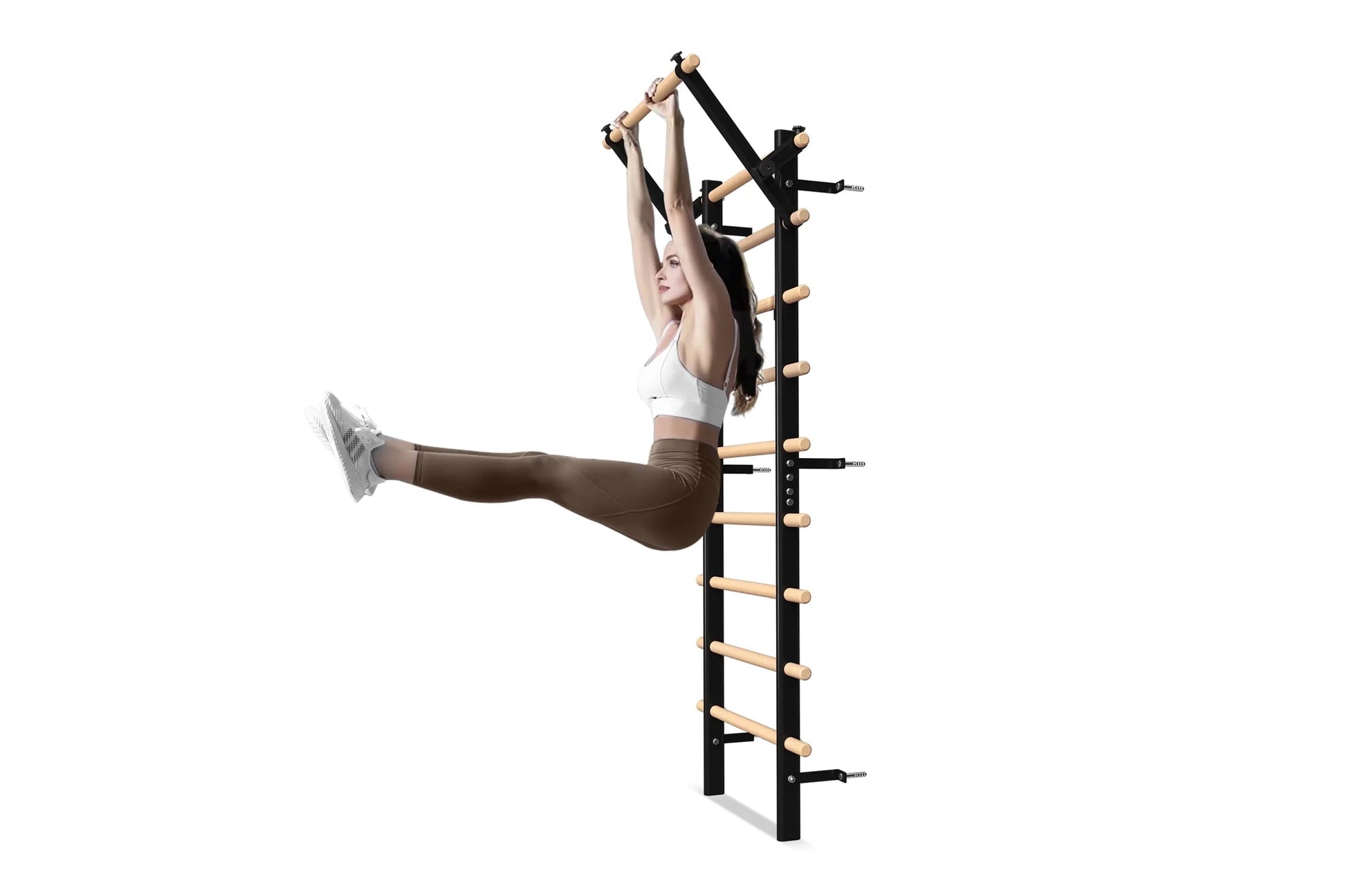 Black and natural wood wall-mounted Swedish stall bars with horizontal wooden rungs, shown in use by model wearing white spor