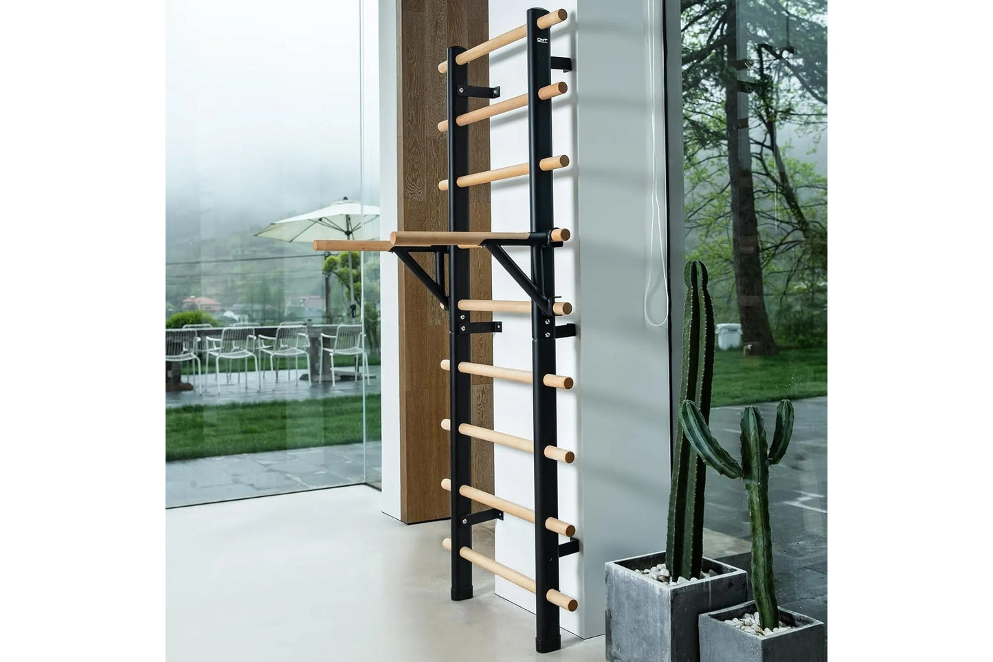 Black metal and natural wood wall-mounted ladder bar with horizontal rungs, installed against brown wood paneling in modern i