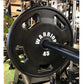 Warrior 45-pound black urethane Olympic grip weight plate with white text, displayed on barbell in gym setting