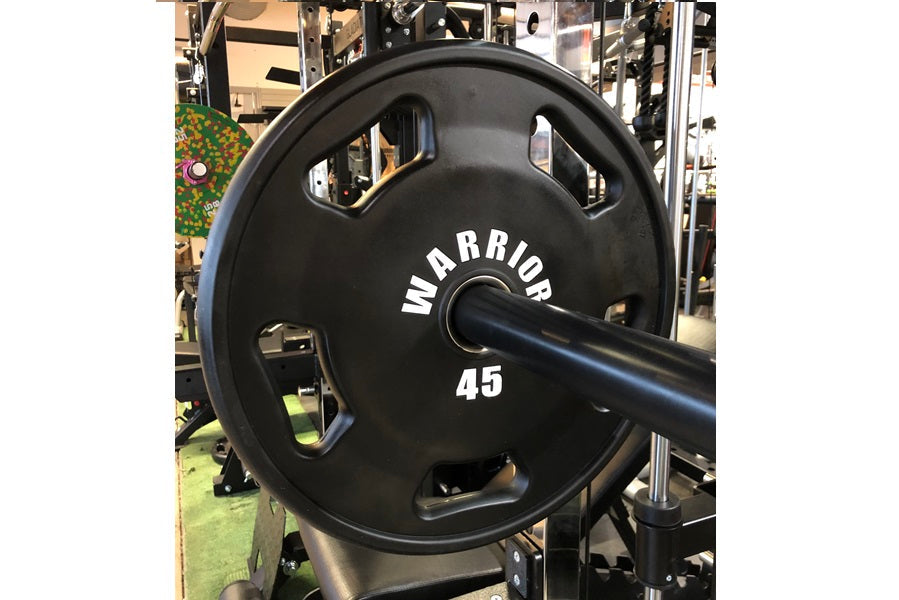 Warrior 45-pound black urethane Olympic grip weight plate with white text, displayed on barbell in gym setting