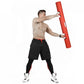 Shirtless man holding red foam training tube overhead, wearing black shorts with red trim and white sneakers on white backgro