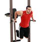Man wearing red sleeveless shirt performing dip exercise on brown metal power tower with black padding and handles