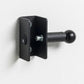 Black wall-mounted fold-up squat rack attachment with adjustable J-cup and lever arm, mounted on white wall