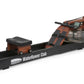 WaterRower Club rowing machine with wooden frame, black footrest, digital display monitor, and water resistance tank on white