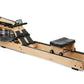 WaterRower rowing machine with natural oak wood frame, black straps and accents, water resistance tank, and black cushioned f