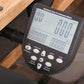 WaterRower Series IV Performance Monitor with digital display showing workout metrics, mounted on wooden rowing machine with 