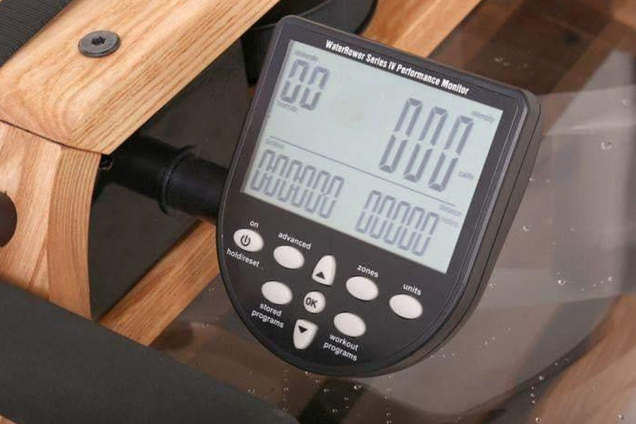 WaterRower Series IV Performance Monitor with digital display showing workout metrics, mounted on wooden rowing machine with 