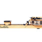 WaterRower Xeno Muller Signature Edition rowing machine with natural wood frame, black mechanical components, and water resis