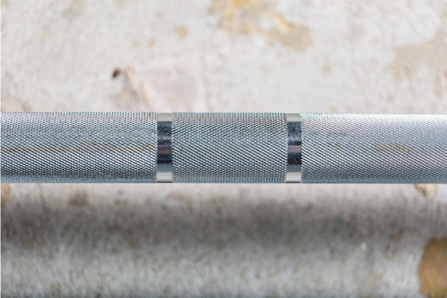 York Women's Elite Competition Olympic Bar with gray textured knurled grip and metal sleeves, closeup detail view