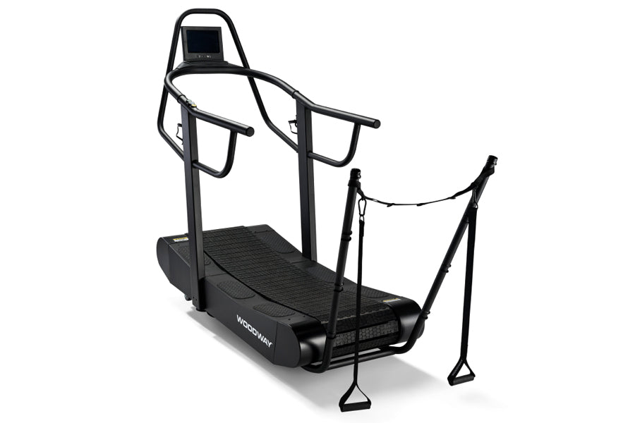 Woodway Curve FTG black treadmill with curved running surface, dual handrails, digital display, and foot pedals on white back